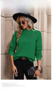 Détail d'un haut vert foncé à col en V avec motif en losange et boutons décoratifs