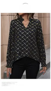 Detail of V-neckline with ruffles and metallic gold plaid print on black long sleeve shirt