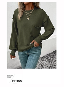 Detail of olive green knit sweater with dropped shoulders and ribbed cuffs and hem