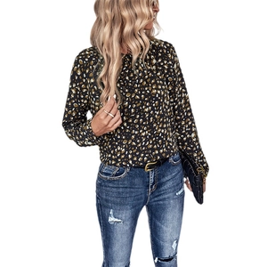 Women's leopard print long sleeve shirt paired with slim blue jeans on white background