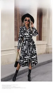 Close-up of long sleeve dress with black and white abstract print and buttoned lapel