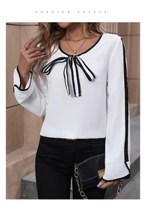Detail of white chiffon blouse with black bow tie neck and contrast sleeve stripes