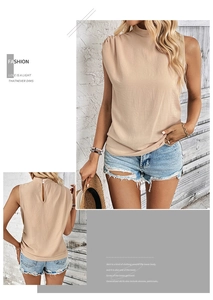 Detail of apricot sleeveless pleated blouse featuring high neck and back button closure