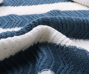 Macro detail of blue and white striped cable knit fabric with soft wool texture