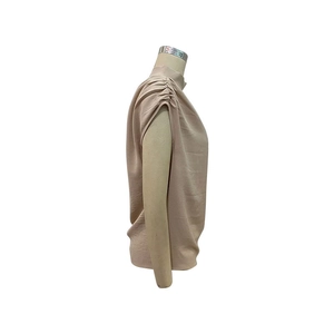 Detail view of apricot sleeveless high neck blouse with pleated shoulder accents