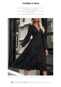Détail d'une robe noire à volants avec col en V, boutonnage frontal et taille ajustée