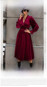 Detail of elegant burgundy velvet maxi dress with V-neckline and ruffled cuffs decoration
