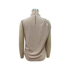 Detailed back view of sleeveless pleated blouse with button closure and slit design