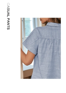 Détail d'une chemise à manches courtes rayée bleu et blanc avec col et revers de manche
