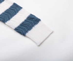 Close-up of blue and white striped knit sweater cuff with wavy texture and ribbed edges