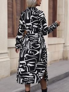 Modisches Hemdblusenkleid mit schwarz-weißem Abstraktmuster, Bindegürtel und Seitenschlitz