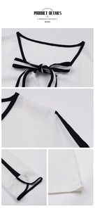 Detail showing contrast piping, bow neckline and curved cuffs on a white chiffon shirt
