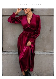 Detail of burgundy velvet dress featuring elegant ruffles and a deep V-neck design