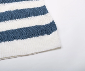 Detail of blue and white striped knit sweater with unique wave texture and ribbed hem