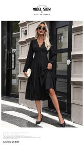 Détail d'une robe noire boutonnée à col en V avec jupe à volants et taille ajustée