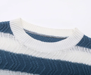 Detail of blue and white striped knit sweater showing ribbed crew neck and cable texture