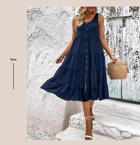 Close-up of dark blue sleeveless tiered dress with wooden buttons and a layered skirt