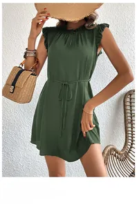 Close-up of sleeveless green dress featuring ruffled sleeve edges and waist drawstrings