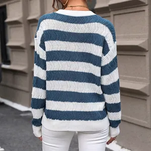 Outdoor back view of a blue and white striped crewneck knit sweater with textured patterns