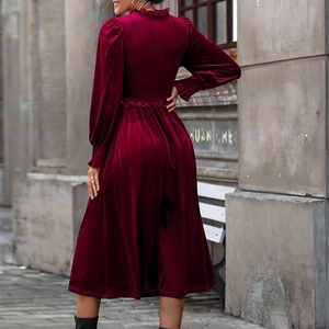 Elegant wine red velvet midi dress with ruffle neck and long sleeves in a street setting