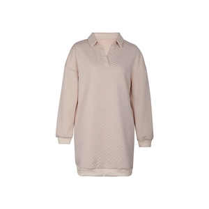 Detail of light pink sweatshirt dress featuring textured diamond-grid quilted fabric texture