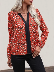 Detail of V-neck collar with contrast black trim and floral chiffon pattern