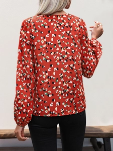 Rear view of casual V-neck blouse featuring vibrant red floral print and elastic cuffs