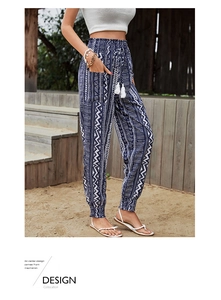 Detail of high waisted bohemian navy trousers with white geometric prints and tassel drawstrings