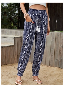 Detail of high waisted bohemian print pants with drawstring tassels and side pockets
