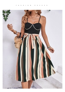 Detail of metal chain neckline and colorful striped pleated skirt on a summer dress