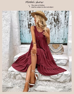 Detail of burgundy sleeveless tiered maxi dress with black buttons on a patio