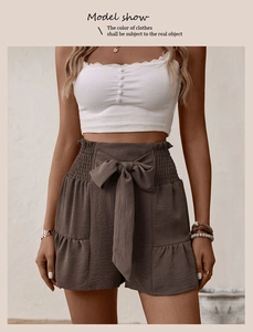 Detail of high waisted wide leg shorts with a large decorative bow tie and elastic waistband