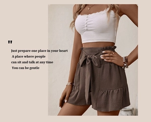 Detail of high-waisted brown casual shorts with elegant tie-up bow and ruffle hem design