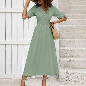 Detailed view of the V-neckline and decorative white buttons on a sage green summer dress
