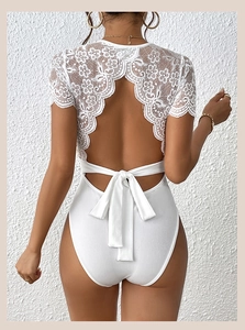 Détail du body blanc avec dentelle florale exquise au dos et fermeture à nœud papillon