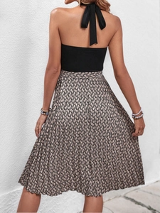 Détail du nœud licou sur une robe plissée dos nu avec imprimé chaîne élégant