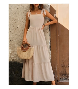 Detail of square neck beige summer dress with shoulder ties and tiered cake skirt