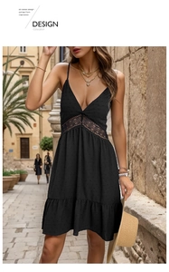 Detail of delicate lace patchwork and polka dot texture on a black V-neck summer dress