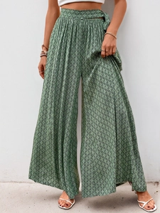 Détail du pantalon large à taille haute avec imprimé géométrique vert foncé et fluide
