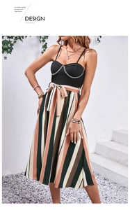 Detail of striped midi dress featuring black ribbed bodice and gold chain accent at neckline