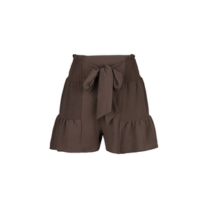 Detail of smocked high waist shorts with coffee brown drawstring bow and ruffled hem