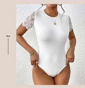 Détail de ce body blanc en maille côtelée avec de la dentelle florale sur les manches courtes