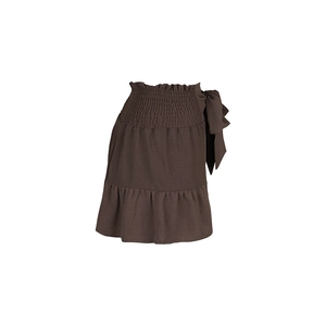 Detail of high waisted brown smocked mini shorts with side bow and ruffled hem