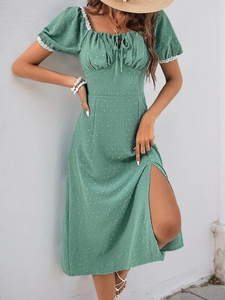 Detail of sage green Swiss dot dress featuring white lace trim on puff sleeves and side slit