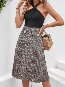 Détail du haut dos nu croisé et jupe plissée à taille haute avec nœud de ceinture