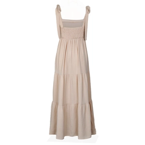 Detail of apricot tiered dress with smocked bodice and shoulder tie ribbons