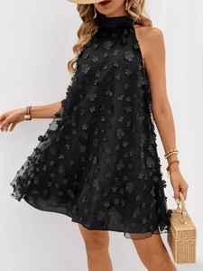 Détail de la robe noire en organza avec fleurs 3D appliquées et design dos nu élégant