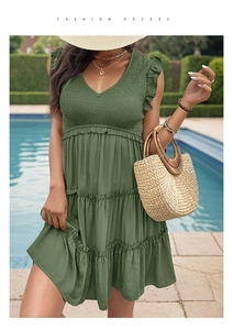 Detail of olive green summer dress featuring V-neckline and tiered ruffle skirt texture
