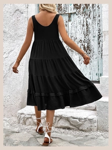 Detail of tiered black sleeveless midi dress with pleated texture on outdoor model back