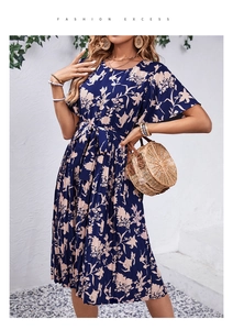 Détail d'une robe d'été fleurie bleu marine avec manches volantées et ourlet plissé